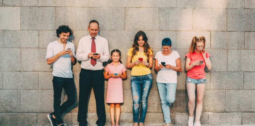 Group-of-people-lined-up-against-wall-using-phones-16_9-1200x675.jpg