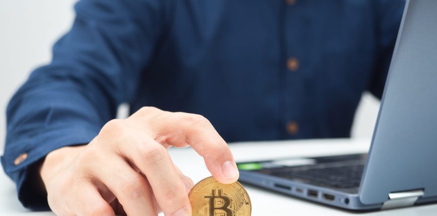 vecteezy_close-up-hand-holding-golden-bitcoin-on-the-table-with_16685301-scaled.jpg