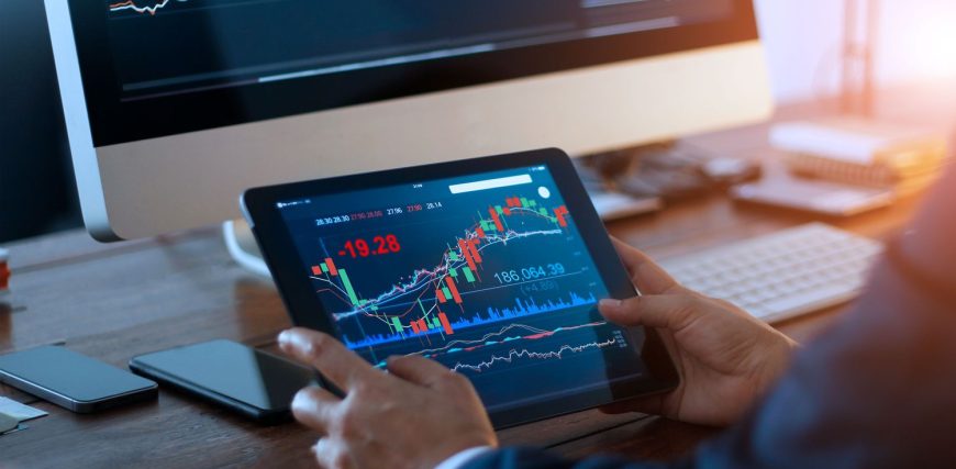 businessman-checking-stock-market-on-digital-tablet-and-a-desktop-computer-with-stock-exchange-graph.jpeg