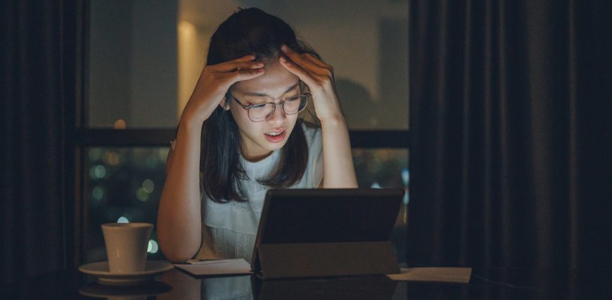 concerned-young-person-with-head-in-hands-gazing-at-a-screen.jpg