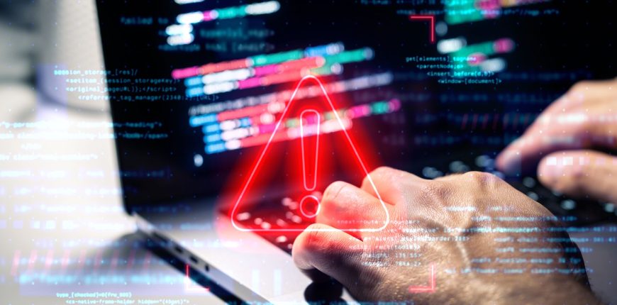 male-hands-using-laptop-with-alert-symbol.jpg