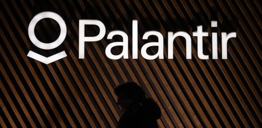 image-of-a-person-walking-in-front-of-a-palantir-logo.jpg