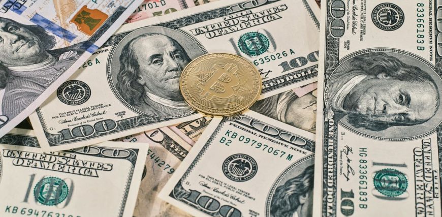 bitcoin-coin-on-scattered-us-hundred-dollar-bills.jpg