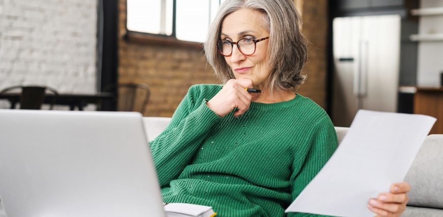 senior-woman-checks-computer-while-holding-paper-social-security-concept_iStock-1304164533.jpg