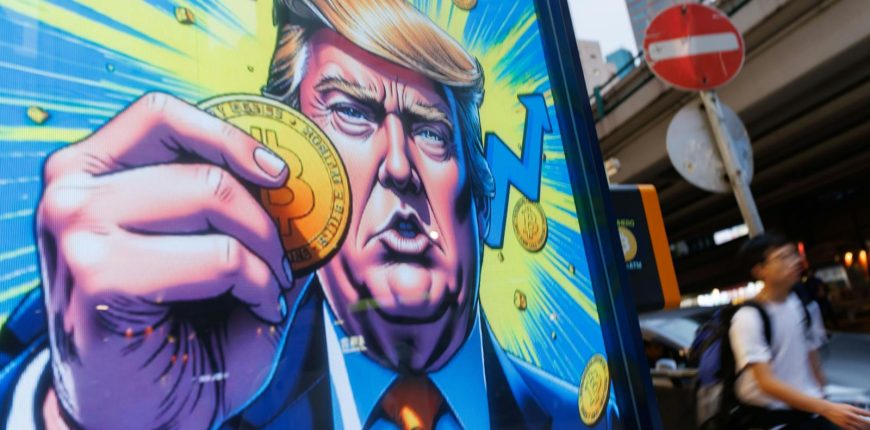 2208409748_people-walk-past-an-advertisement-feature-donald-trump-with-bitcoin-in-hong-kong-on-sunda.jpeg