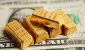 gold-bars-atop-dollar-bills-economy-investing-concept_iStock-1472696526.jpg