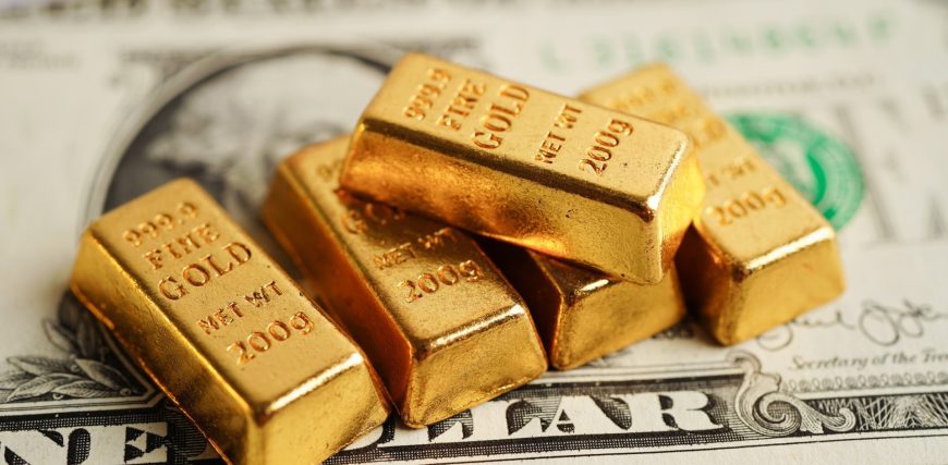 gold-bars-atop-dollar-bills-economy-investing-concept_iStock-1472696526.jpg