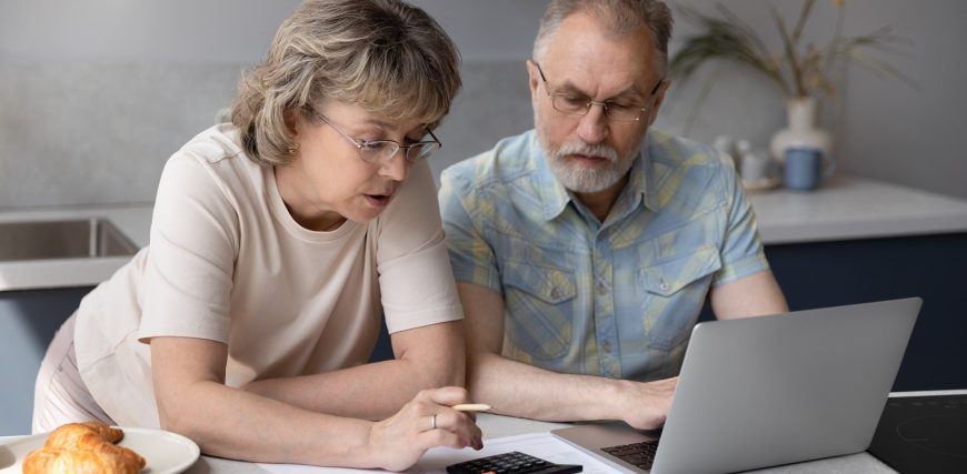 senior-mature-couple-discuss-finances-over-breakfast-at-laptop-calculator_iStock-1352716482.jpg