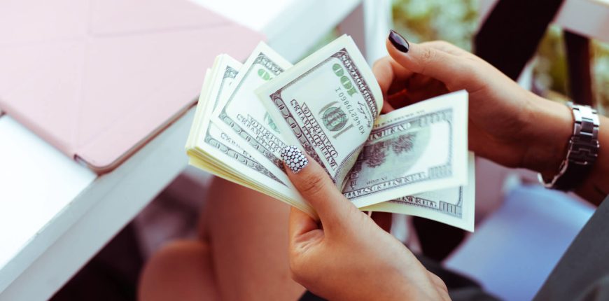 Woman-counting-hundred-dollar-bills-in-her-hands-iStock-1035819410.jpg