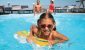 girl-in-sunglasses-swimming-with-float-in-a-pool-adults-relaxing-in-background.jpg girl-in-sunglasses-swimming-with-float-in-a-pool-adults-relaxing-in-background.jpg